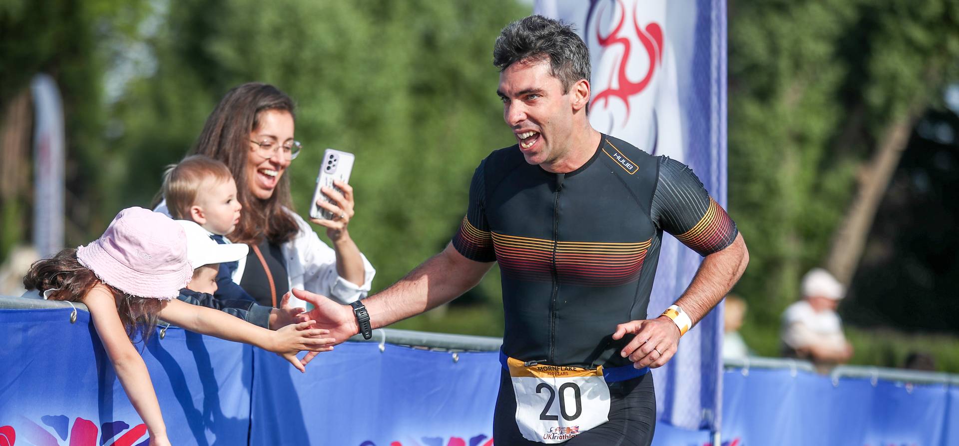 Triathlon challenger running past their family