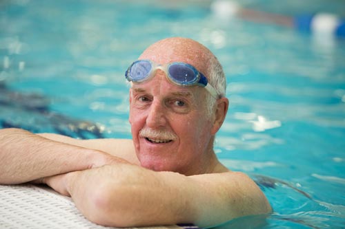 Charles, stood in a swimming pool with goggles on.