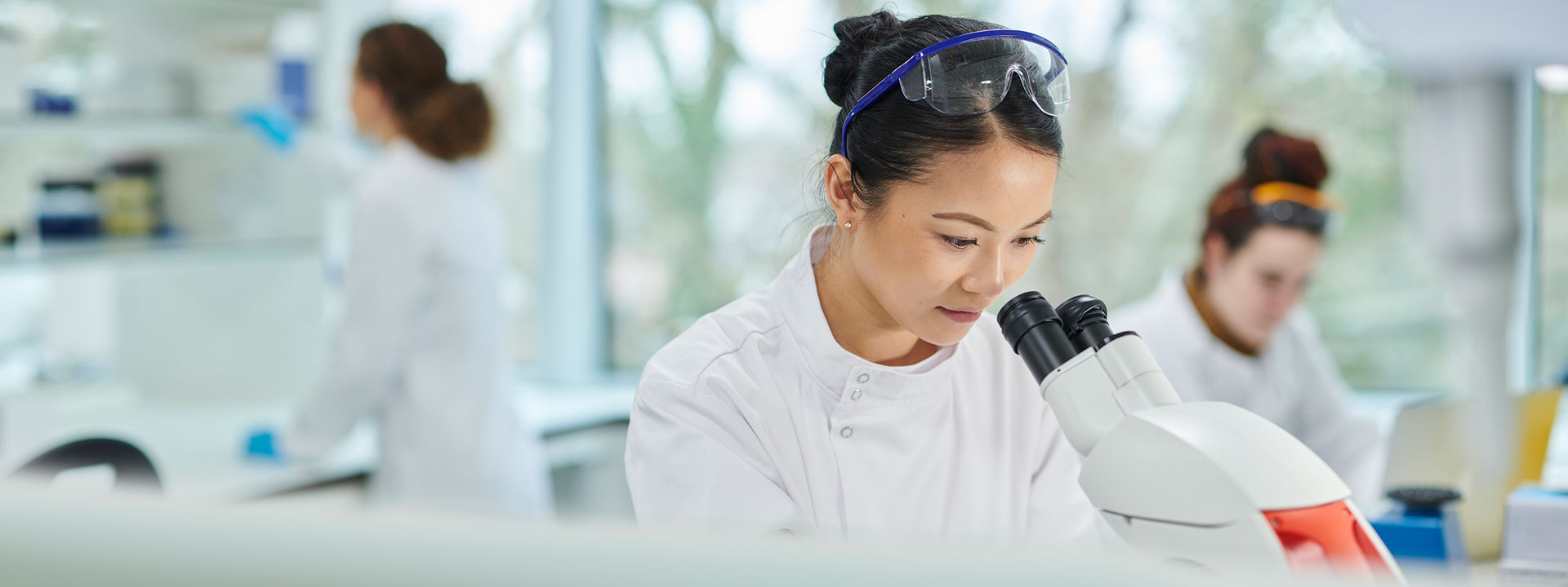 Arthritis researcher looking into a microscope