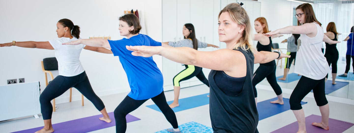 Six women doing yoga, showing the importance of exercising for Arthritis.