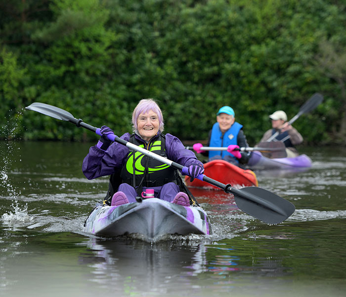 Older women with arthritis, kayaking on a lake