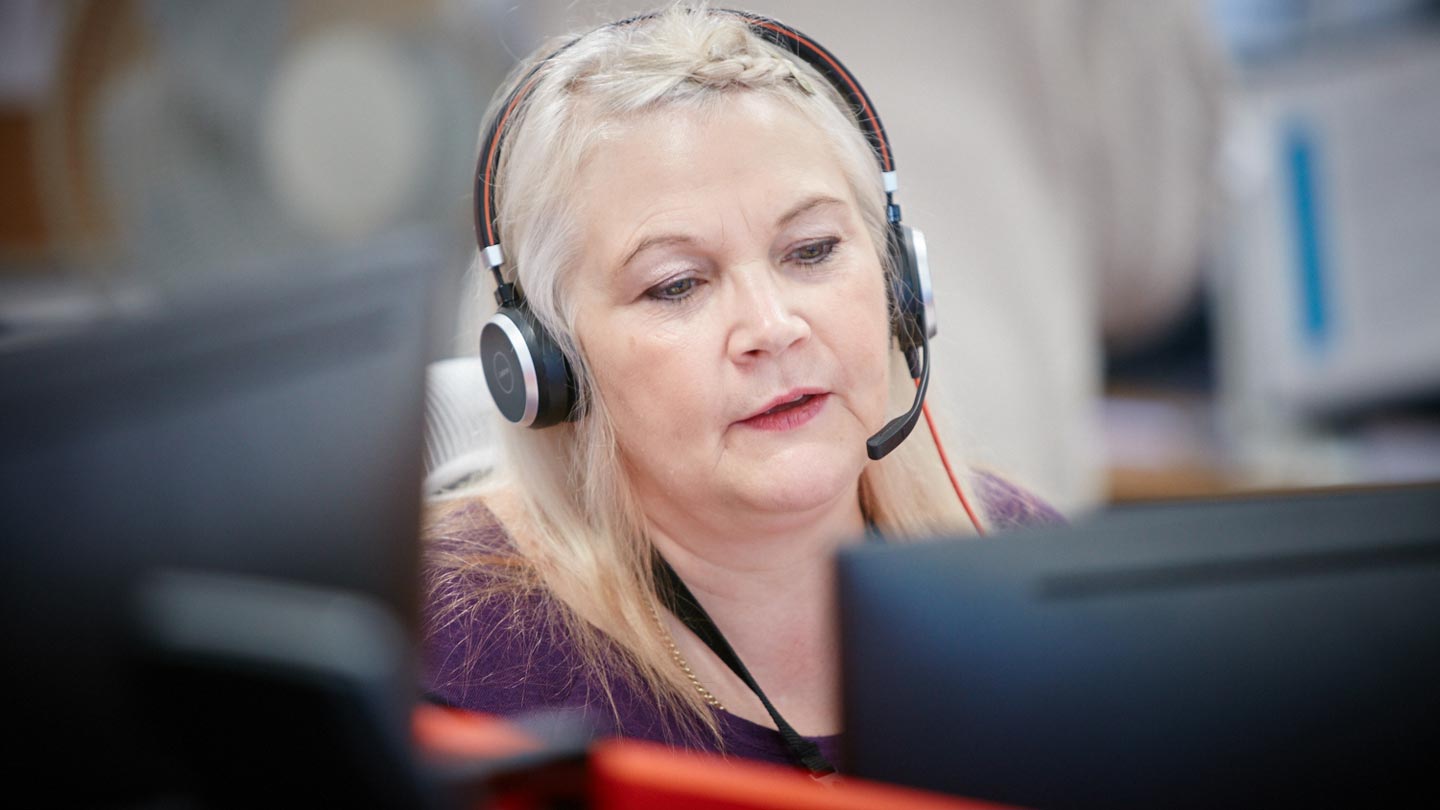 A helpline worker on a call looking at a computer screen