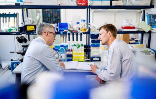 Two researchers talking in a lab