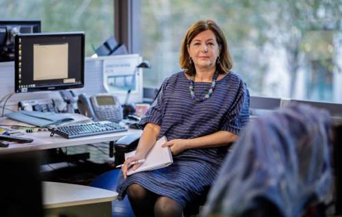 Dorothy sitting in newsroom holding a notepad