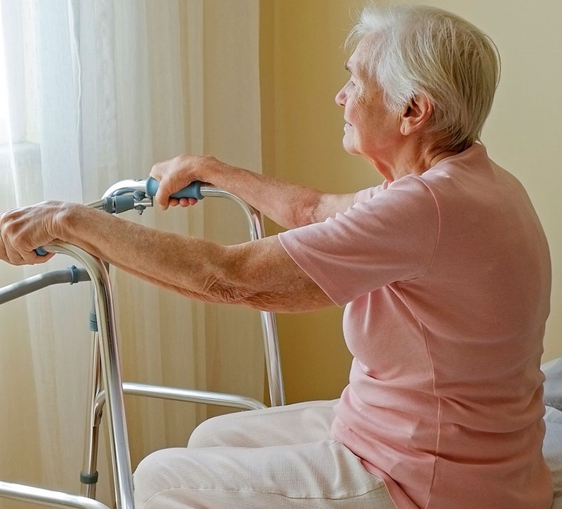 Lady using frame to get out of bed