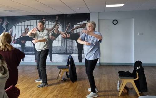 Paul and Anne wearing sports clothes peacefully practicing Tai Chi