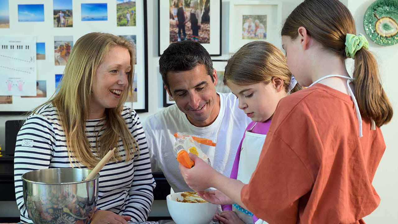 Family of mum living with arthritis, dad and two kids baking together at home